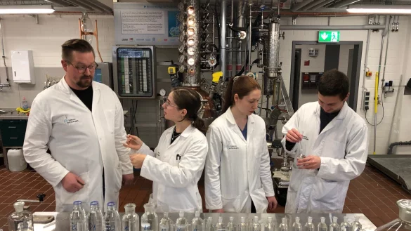 Schnapsprobe in der Getr&auml;nketechnologie an der Technischen Hochschule OWL: (von links) Braumeister Christian Schulze bespricht mit Lilli Reichel, Carolin Grot und Paul Sieker das Ergebnis des Prozesses, der kurz zuvor in der Destille im Hintergrund abgelaufen ist. In den verschiedenen Fl&auml;schen ist der Brand in Vor-, Mittel- und Nachlauf getrennt. Die "Goldene Mitte" schmeckt dabei klar am besten. - &copy; Thomas Reineke