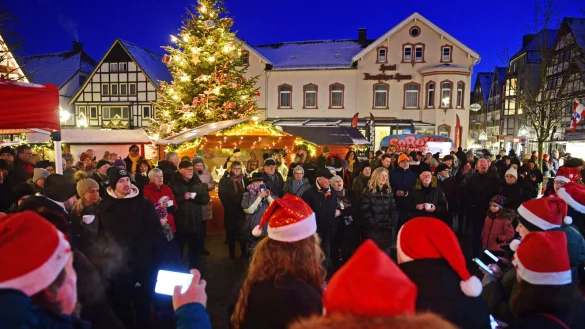 Chor und Besucher singen gemeinsam auf dem weihnachtlich geschm&uuml;ckten Marktplatz. - &copy; Nicole Ellerbrake