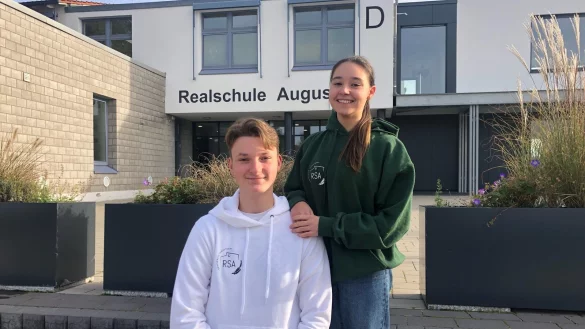 Die Sch&uuml;lersprecher Younes Belhadj und Bianca Benchea zeigen den Hoodie mit dem neuen Logo der Augustdorfer Realschule. - &copy; Edith Kemeny