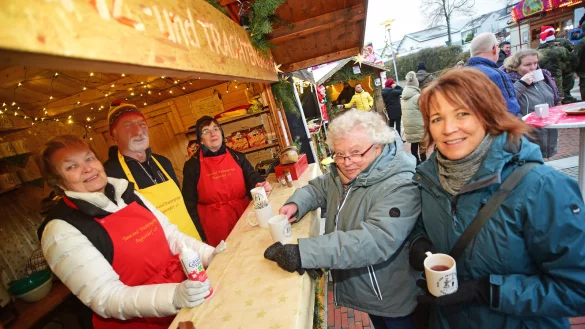 Sigrid Korndorf, Eberhard Staude und Annegret Stritzker (von links) in dem H&auml;uschen der Tanz- und Trachtengruppe auf dem Augustdorfer Weihnachtsmarkt. An der Theke stehen Gretel und Sirkku Mai (von links). - &copy; Nicole Ellerbrake