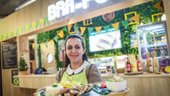 Camilia Giannoni präsentiert eine Auswahl brasilianischer Speisen vor ihrem Imbiss Bra Food im Harms-Markt. - © Sarah Jonek