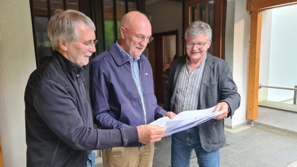 Die Initiatoren Udo Zippel (von links), Professor Dr. Rolf-Dieter Weege und Professor Dr. Hans-J&uuml;rgen Danneel blicken vor dem Dorfgemeinschaftshaus in Westorf in die ersten Unterschriftenlisten. - &copy; Nadine Uphoff