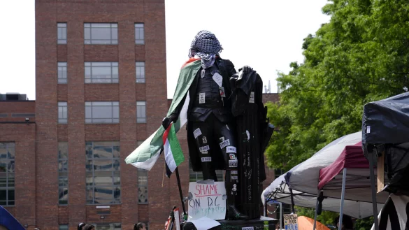 Die Statue von George Washington ist mit Aufklebern, einer pal&auml;stinensischen Fahne und einer Keffiyeh in der N&auml;he eines Studentenlagers auf dem Campus der George Washington University bedeckt, w&auml;hrend Studenten protestieren. - &copy; dpa