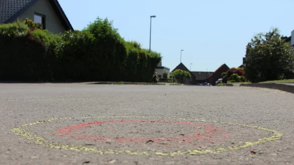 34 gelb-rot markierte Kreise (das Bild zeigt einen davon) auf der Stra&szlig;endecke in der Salzufler Sackgasse deuten genau auf die Stellen hin, wo die Spurensicherung am Einsatzort Patronenh&uuml;lsen sichergestellt hat. F&uuml;nf Kugeln trafen den damals 19-j&auml;hrigen Fahrer. - &copy; Janet K&ouml;nig
