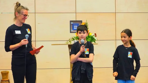 Schulleiterin Beate Busse begr&uuml;&szlig;t zusammen mit den Schulsprechern Hira (rechts) und Cenk die G&auml;ste in der vollbesetzten Sporthalle. - &copy; Stiftung Eben-Ezer