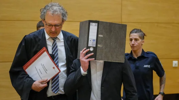 Der Angeklagte verdeckt sein Gesicht mit einem Ordner. Er soll seine Kollegin bei einer Party erstochen haben. - &copy; Andreas Zobe (Archiv)