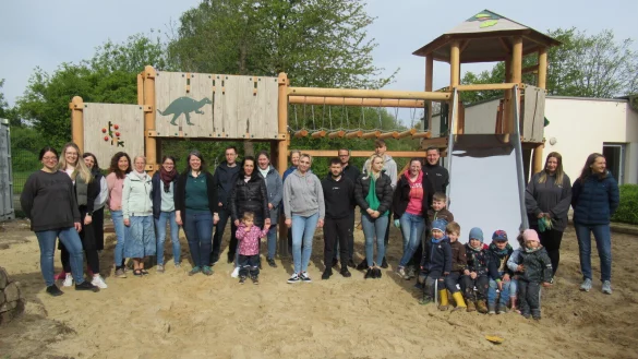 Kinder, Eltern und Mitarbeitende der Kindertageseinrichtung am Weidenbusch freuen sich &uuml;ber den neuen Kletterturm auf dem Au&szlig;engel&auml;nde. - &copy; Kita am Weidenbusch