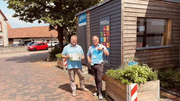 Henning Schwarze (links) und B&uuml;rgermeister Marcus P&uuml;ster zeigen das Faltblatt mit zehn n&uuml;tzlichen Tipps gegen die Hitze. - &copy; Fotorechte: Gemeinde Schlangen
