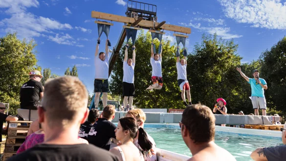 Beim Spiel &bdquo;Spijkerbroekhangen&ldquo; h&auml;ngen die Teilnehmer wie hier 2022 an Hosen &uuml;ber dem Pool. - &copy; Daniel Winter