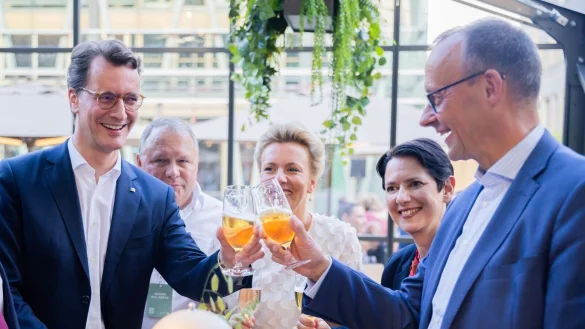 Hendrik W&uuml;st und Friedrich Merz sto&szlig;en beim Sommerfest der Landesvertretung Nordrhein-Westfalen beim Bund an. - &copy; Christoph Soeder