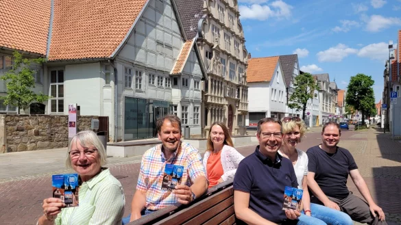 Im Hintergrund ist eines der Ziele des digitalen Stadtrundgangs zu sehen - das Hexenb&uuml;rgermeisterhaus. Auf der Bank haben auf der linken Seite (von vorne) Liesel Kochsiek-Jakobfeuerborn, Werner Kuloge und Lysann Rehberg Platz genommen. Links sitzen Ingo Kleine (vorne), Ingrid Krah und Fabian Schr&ouml;der. - &copy; Astrid Sewing