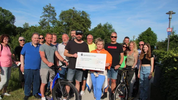 &Uuml;ber 4000 Euro kamen bei der Tretroller-Spendentour nach Norderney zusammen. Tobias B&ouml;hm (am Tretroller, von links), Andr&eacute; Willh&ouml;ft und Steven Mei&szlig;ner (Tretroller links) &uuml;berreichen L&ouml;wenmama Susanne Saage den symbolischen Spendenscheck. - &copy; Katrin Kantelberg