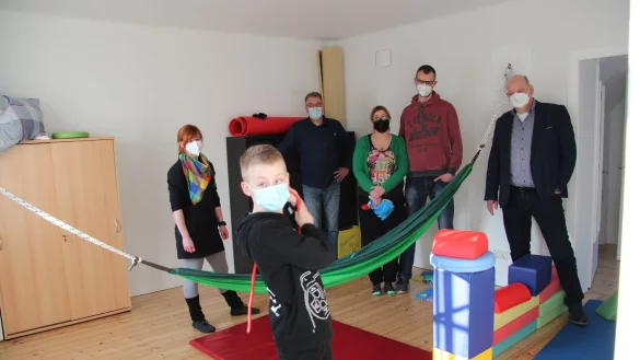 Sam ist in seinem Element: Im Therapieraum kann er nach Herzenslust spielen und toben. Hinter ihm (von links) Lisa Poser, Olaf Hanke, Melanie und Andre Schmidt und Eckhardt Maaß von der Allianz Generalvertretung Detmold. Foto: Silke Buhrmester - © Silke Buhrmester