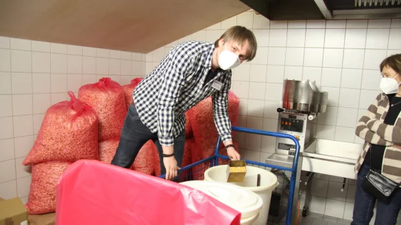 Matthias Pabst steht in der Popcorn-K&uuml;che und zeigt, wie die gepuffte S&uuml;&szlig;igkeit hergestellt wird. Etwa 30 S&auml;cke (im Hintergrund) gehen an einemWochenende drauf. - &copy; Kirsten Fuhrmann