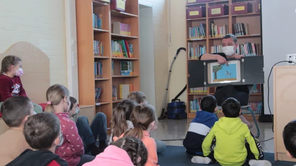 Die Schülerinnen und Schüler der Klasse 1a der Grundschule An der Senne lernen spielerisch, dass "Anders sein" anderer zu akzeptieren und wertzuschätzen. Referentin Simone Adams-Weggen bespricht dafür einzelne Szenen mit den Kindern. - © Karolina Schmidt