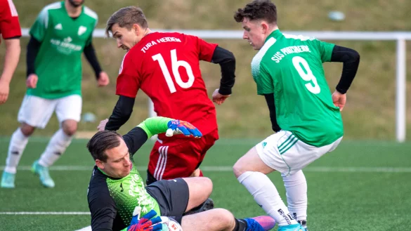 Brandgef&auml;hrlich: Der Pivitsheider Danny Enns (gr&uuml;n, 9) sorgt f&uuml;r Gefahr vor dem Heidener Tor. Keeper Thomas Hertel (am Boden) und Peter Werner (rot, 16) k&ouml;nnen die brenzlige Situation gemeinsam kl&auml;ren. - &copy; EGON PENNER