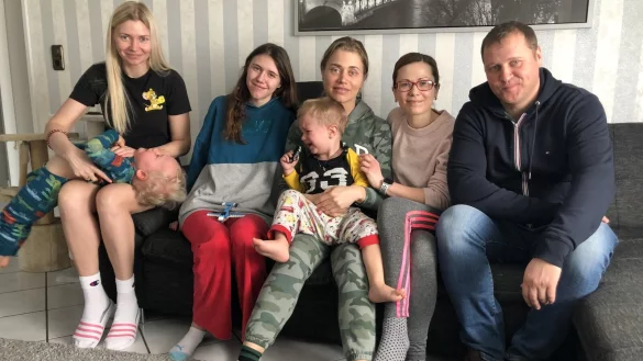 Natalia (von links) mit Sohn Mathew und Tochter Milena, Helena mit Sohn Timur sowie Ina und Dennis Zinn sitzen im Wohnzimmer der Bad Salzufler. - © Sven Kienscherf