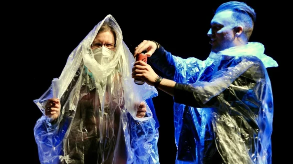 Bekleidet mit Plastik-Capes spielten Zuschauerin Anja und Magier Christopher K&ouml;hler in der Konzerthalle russisches Roulette mit Cola-Dosen. - &copy; Heidi Stork