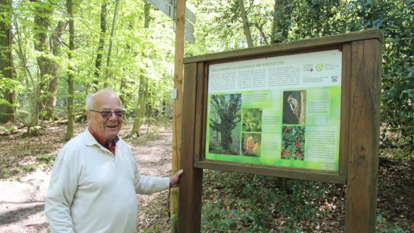 Adolf Nagel steht an einer Infotafel zum B&auml;renstein, der auch auf der Strecke der Blaubeer-Route liegt. - &copy; Dieter Asbrock