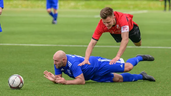 Hartes Tackling: Daniel Simon von den Sportfreunden Berlebeck-Heiligenkirchen (blau) attackiert hart und unfair den Augustdorfer Spielf&uuml;hrer Joel Weber. - &copy; EGON PENNER