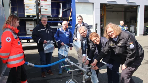 Wasser, marsch: Christiane Vieweger (Leiterin THW-Regionalstelle
Bielefeld), Sabine Beine, Thomas Lammering, Dr. Kerstin Ahaus (Leiterin
Gesundheitsamt), Dirk Kuchenbecker und Meinolf Haase (Leiter
Bevölkerungsschutz, von rechts) lassen sich von Jennifer Röder vom
DRK-Ortsverein Detmold zeigen, wie an einer Ausgabestelle das gereinigte Wasser
in Fünf-Liter-Beutel abgefüllt wird. - © Kreis Lippe