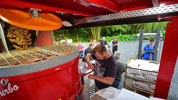Ratsmitglieder und Feuerwehrleute f&uuml;llen an der Maschine Sand in die Sands&auml;cke ab. - &copy; Nicole Ellerbrake