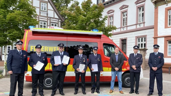 Feuerwehr-Chef Joachim Hartfelder, die Geehrten Maik Lohmeier-Feuerwehrchef Joachim Hartfelder, Maik Lohmeier-Schaeffer, Markus Ri&szlig;mann, Marcel Blinne, Edgar Finke, B&uuml;rgermeister Christoph Dolle sowie die stellvertretenden Wehrf&uuml;hrer Heiko M&uuml;hlenmeier und Cord Finke (von links) vor dem neuen Einsatzwagen am Rathaus. - &copy; brink-medien