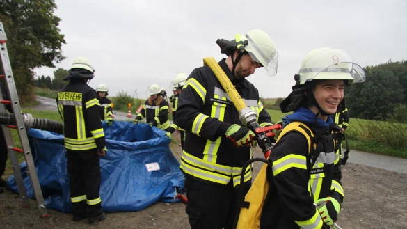 S&ouml;ren Hollensteiner f&uuml;llt bei Darius B&uuml;ker (rechts) einen L&ouml;schrucksack. - &copy; Daniel Hobein/Feuerwehr Bad Salzuflen