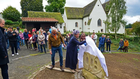 Vor der Kulisse der Peterskirche enth&uuml;llen K&uuml;nstlerin Renate L&uuml;bbing und Bildhauer Helmut Sch&ouml;n den Jubil&auml;umsstein. - &copy; Nicole Ellerbrake