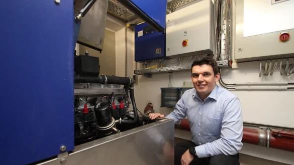 Yannic Hausmann, neuer Klimaschutzmanager der Gemeinde Extertal, mit dem Blockheizkraftwerk im Keller des Rathauses. Das erzeugt W&auml;rme und Strom aus Gas - zwar nicht CO2-neutral, aber effizienter als viele andere Heizungen auch in Geb&auml;uden der Gemeinde Extertal. - &copy; Jens Rademacher