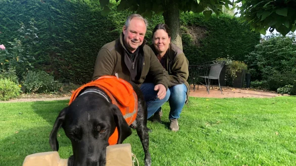 Andreas und Nina Wolf mit Hund &bdquo;Cora&ldquo;, die eine Jagdweste tr&auml;gt und einen Apportierbock im Maul hat. Foto: Sven Kienscherf - &copy; Sven Kienscherf