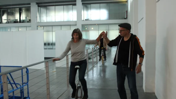 Kursleiter Jens Heuwinkel leistet Edeltraud Kuhlmeier Hilfestellung beim Einradfahren. - &copy; Chiara Wibbeke