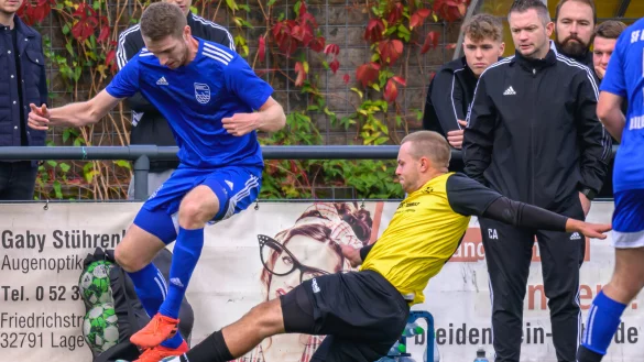 Steven Petrov vom FSV Pivitsheide (gelb) geht gegen Arne Seehricht von den SF Berlebeck-Heiligenkirchen resolut in den Ball. SF-Trainer Christopher Andr&eacute; (rechts) beobachtet aufmerksam den Zweikampf. - &copy; EGON PENNER