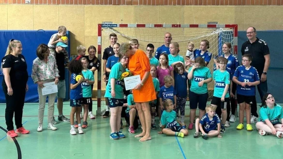 Ein emotionaler Moment: Die Soroptimistinnen Sonnja Wehning (Bildmitte) und Stefani Quentell (Zweite von links) &uuml;bergeben den Spendenscheck, die "Super Kidz" bedanken sich mit Blumen und Umarmungen. - &copy; Sporoptimist Club Detmold