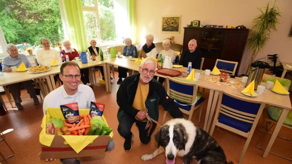 Der Gesch&auml;ftsf&uuml;hrer der Diakonie, Volker Sasse (von links), Helmut Tiek&ouml;tter, Vorsitzender des Bielefelder Tierschutzvereins, und H&uuml;ndin Bella freuen sich zusammen mit den Senioren der Tagespflege &uuml;ber die gesammelten Spenden. - &copy; Nicole Ellerbrake