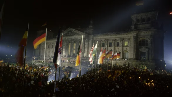 "Fest der Einheit": Menschen feiern vor dem Berliner Reichstag in der Nacht vom 2. zum 3. Oktober 1990 die Wiedervereinigung. - &copy; picture-alliance / akg-images