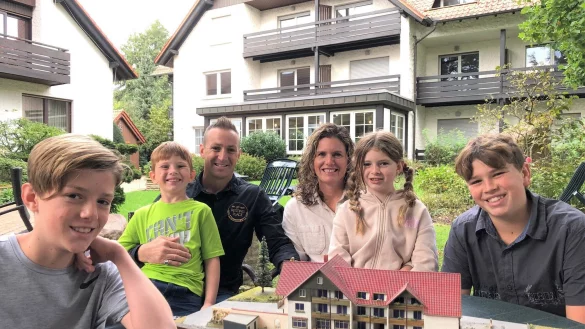 Die Gastronomie-Familie Willoughby im Biergarten von "The Resting Place", dem ehemaligen Hotel-Restaurant "Im Borke". Auf dem Tisch steht ein &auml;lteres Modell des Hotelgeb&auml;udes (im Hintergrund). Auf das Treffen mit m&ouml;glichst vielen G&auml;sten in Kirchheide freuen sich (von links) Caleb (13 Jahre alt), Elijah (7), Papa Paul (43), Mama Jeannie (39), Elizabeth (9) und Samuel (15). - &copy; Thomas Reineke