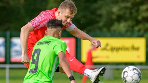 Cedric Berkemeier, Kapit&auml;n des FC Augustdorf, kl&auml;rt in dieser Szene vor dem Ahmsener Peywan Y&uuml;s&uuml;n. - &copy; Egon Penner