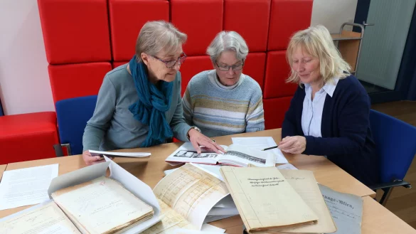 Christel Grote (von links), Gesine Niebuhr und Dr. Bärbel Sunderbrink sehen sich die Unterlagen zur Petri-Stiftung und zum Diakonissenhaus im Stadtarchiv noch einmal genauer an. Sie hoffen aufgrund ihrer Bedeutung auf einen Erhalt der Häuser. - © Alexandra Schaller