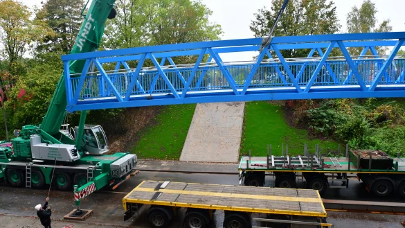 Die Br&uuml;cke schwebt: Ulrich Rittner zieht die blaue Aluminiumbr&uuml;cke mit einem Seil aus der anf&auml;nglichen Position in die richtige Lage. Im Vordergrund ist der hintere Teil des Schwertransporters zu erkennen, auf dem die Br&uuml;cke lag. Fotos: Gunter Held - &copy; Gunter Held