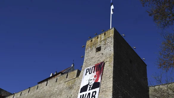 "Kriegsverbrecher Putin" steht an einer Burgmauer in Narwa. - &copy; picture alliance / ASSOCIATED PRESS