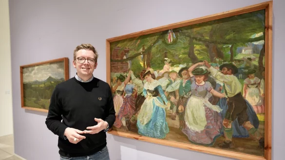 David Riedel, Leiter des Museums Peter August B&ouml;ckstiegel, steht neben Erich Kuithans Bild &bdquo;Bauerntanz vor dem Forsthaus Valepp am Schliersee&ldquo; (1901/02). - &copy; Peter Unger