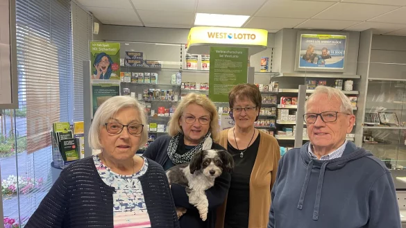 Wilma Lehmann (links) und ihr Mann Hans erinnern sich an schöne Zeiten in ihrem Laden, Mitarbeiterin Rosi Wischnewski (hinten rechts) hat 45 Jahre lang Kunden bedient. Lehmanns Tochter Andrea Hausstätter (hinten links) wird ihr Reisebüro weiterhin betreiben. Hund Milo ist der Top-Berater für Pfötchen-Hotels. - © Silke Buhrmester
