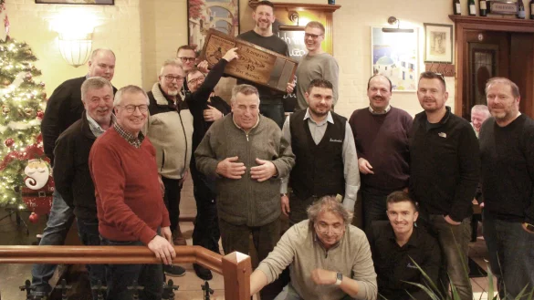 Wettbewerbssieger Viktor D&uuml;ck (stehend mit dem Siegerbrett) nimmt eigenh&auml;ndig die Platzierung der gewonnenen Brett-Troph&auml;e im Restaurant Santorini vor - sehr zur Freude seiner Vereinskameraden. - &copy; Udo Zantow, 32791 Lage
