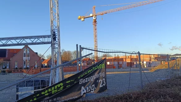 Eigentlich h&auml;tte das Fachmarkzentrum im August 2023 bezugsfertig sein sollen, wie ein altes Plakat am Bauzaun noch verr&auml;t. Wegen eines vom Gericht verh&auml;ngten Baustopps wurde daraus nichts. - &copy; Redaktion LZ