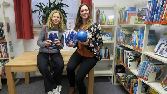 Ellen Lüke (VHS Detmold-Lemgo) und Jasmin Ens (Stadtbücherei Julie Hirschfeld) halten das neue Semesterprogramm in den Händen. - © VHS Detmold-Lemgo