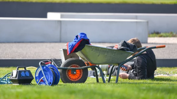 Ein Arbeiter macht neben einer Schubkarre eine Pause. - &copy; Uwe Anspach