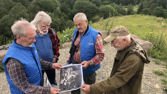 Die Nabu-Mitglieder Bernd M&uuml;hlenmeier (von links), Herbert Goedecke, Andreas Kr&uuml;ger und Reinhard Pape schauen sich ein Luftbild an, auf dem das Gel&auml;nde kurz nach der &Uuml;bernahme durch den Nabu zu sehen ist. - &copy; Sven Kienscherf