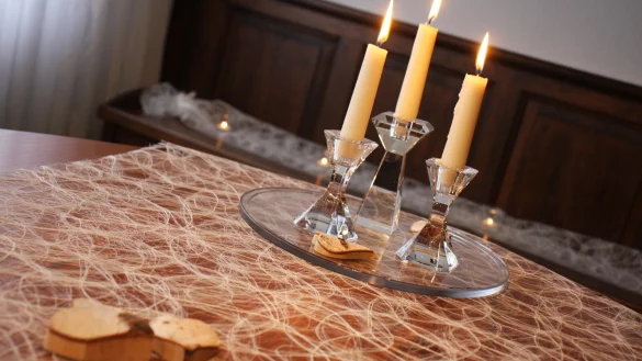 Der Tisch im Trauzimmer ist mit Kerzen und Herzen aus Birkenholz geschm&uuml;ckt. Auf der Sitzbank stehen Teelichter. - &copy; Anne Neul