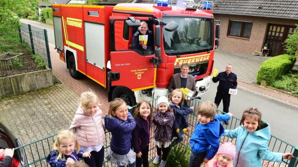 Nur f&uuml;r die Fotografin haben sich die Kinder der Kita &bdquo;Zauberkiste" den Blick auf das Feuerwehrauto mit J&ouml;rg Mengedoht (hinten, von links), Jens Kulsmeier und Frank Lehmeyer zeigen lassen. - &copy; Nicole Ellerbrake
